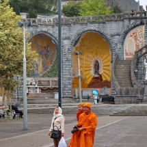 Buddhist monks in front of the chapels Saint Bernadette and Notre Dame de Guadeloupe